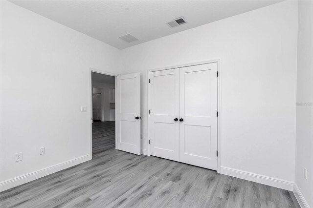 13430 SW 88th Ter, Ocala, FL 34473 - unfurnished bedroom featuring visible vents, light wood finished floors, baseboards, and a closet