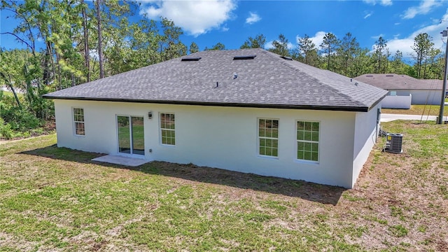 13430 SW 88th Ter, Ocala, FL 34473 - back of property featuring central air condition unit, a yard, a shingled roof, and stucco siding