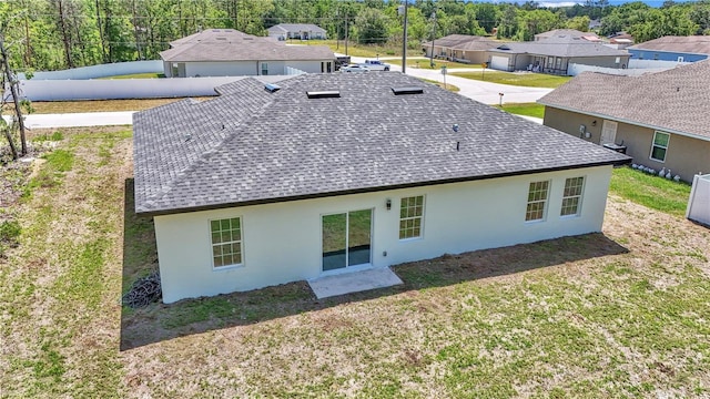 13430 SW 88th Ter, Ocala, FL 34473 - back of house featuring roof with shingles, stucco siding, a yard, and a residential view