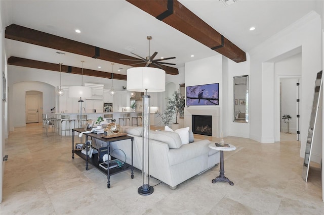5550 Osprey Isle Ln, Orlando, FL 32819 - living area featuring ceiling fan, arched walkways, a fireplace, beamed ceiling, and recessed lighting