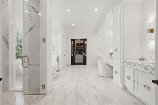5550 Osprey Isle Ln, Orlando, FL 32819 - bathroom with a freestanding bath, vanity, a marble finish shower, marble finish floor, and baseboards