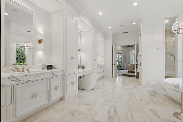 5550 Osprey Isle Ln, Orlando, FL 32819 - bathroom with vanity, ceiling fan with notable chandelier, ensuite bathroom, a soaking tub, and recessed lighting