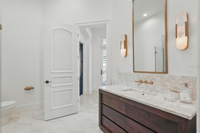 5550 Osprey Isle Ln, Orlando, FL 32819 - bathroom featuring vanity, marble finish floor, baseboards, and toilet