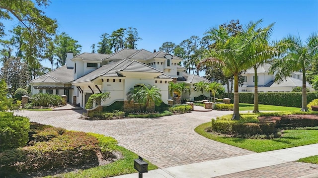 5550 Osprey Isle Ln, Orlando, FL 32819 - view of front facade with curved driveway, an attached garage, stucco siding, and a chimney