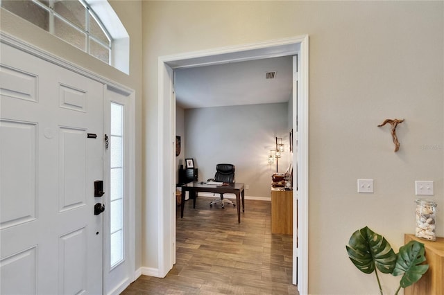 entryway with baseboards, visible vents, and wood finished floors