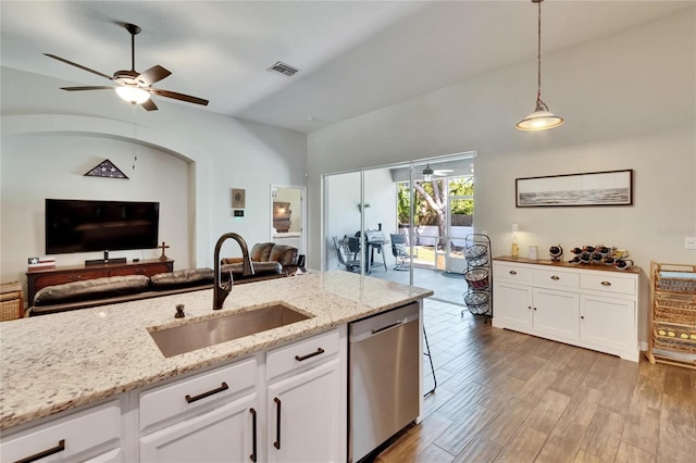 kitchen with a sink, stainless steel dishwasher, open floor plan, and visible vents