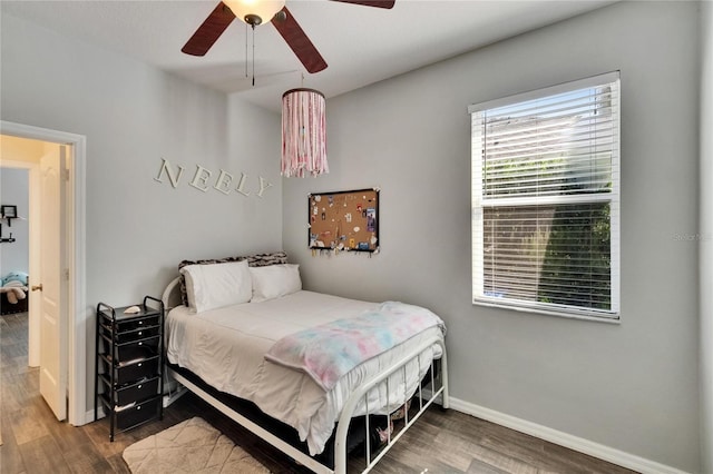 bedroom with baseboards, ceiling fan, and wood finished floors