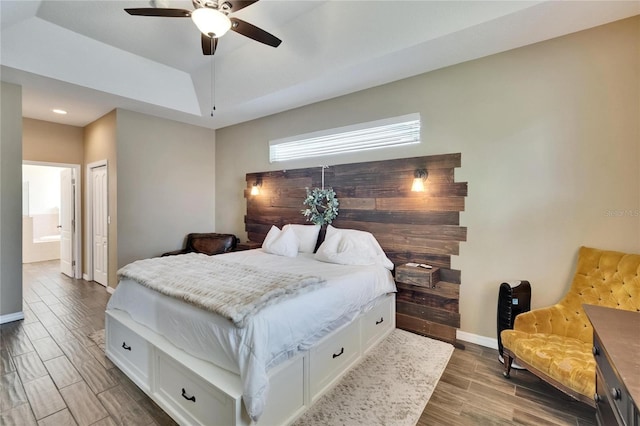 bedroom featuring wood finish floors, ensuite bath, recessed lighting, ceiling fan, and baseboards