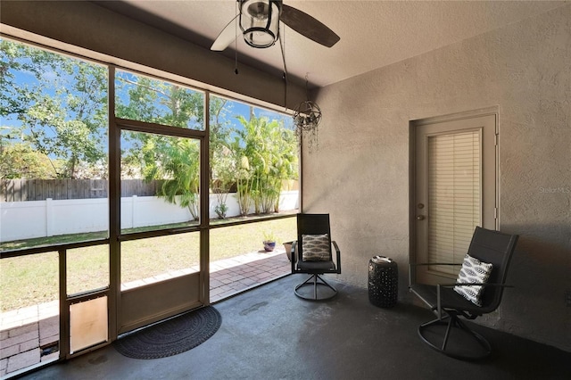 unfurnished sunroom featuring a ceiling fan