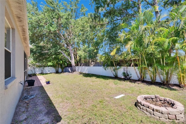 view of yard featuring a fire pit and a fenced backyard