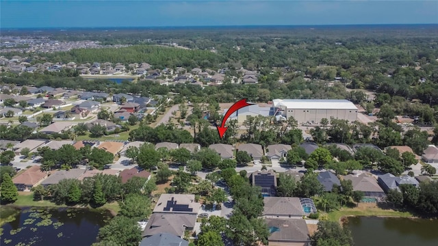 aerial view featuring a wooded view, a water view, and a residential view