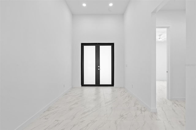 unfurnished room featuring recessed lighting, marble finish floor, baseboards, and french doors