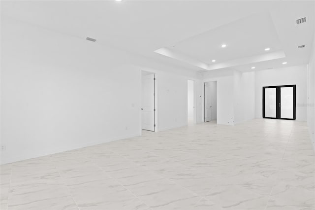 spare room featuring french doors, recessed lighting, a raised ceiling, and visible vents
