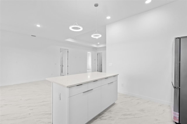 kitchen featuring recessed lighting, freestanding refrigerator, marble finish floor, and white cabinets