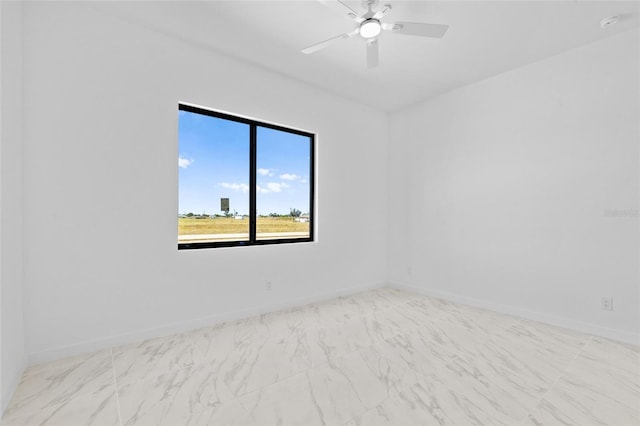 spare room featuring baseboards and ceiling fan