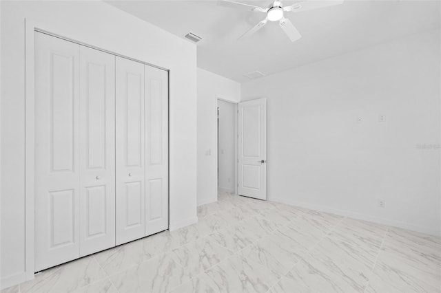 unfurnished bedroom featuring visible vents, a closet, marble finish floor, baseboards, and ceiling fan