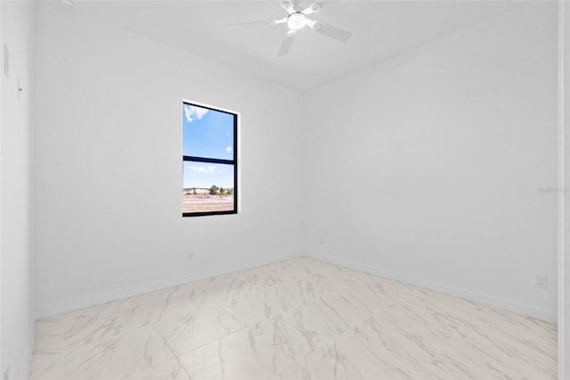 unfurnished room featuring baseboards, marble finish floor, and ceiling fan