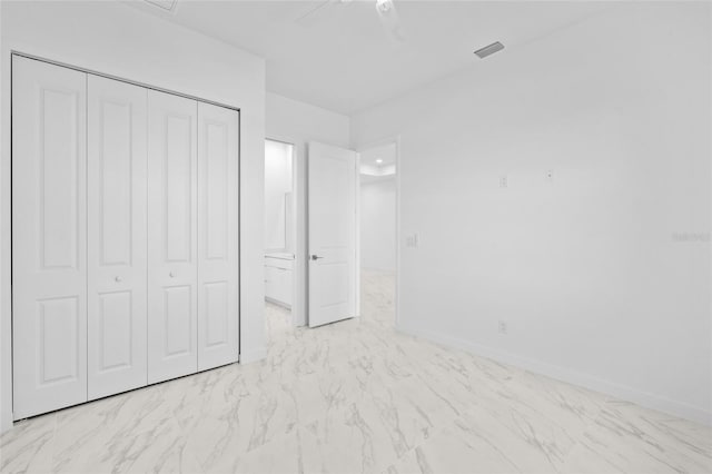 unfurnished bedroom featuring baseboards, ceiling fan, marble finish floor, and a closet