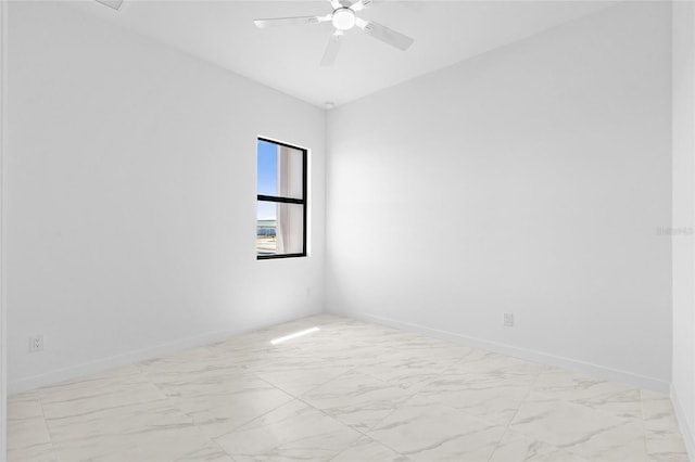 unfurnished room featuring baseboards, a ceiling fan, and marble finish floor