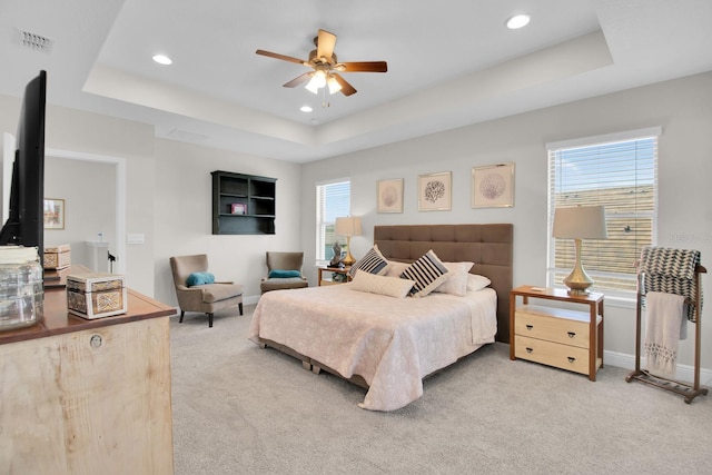 carpeted bedroom featuring visible vents, ceiling fan, a tray ceiling, baseboards, and recessed lighting