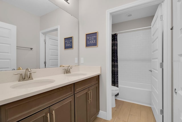 bathroom with toilet, double vanity, a sink, and shower / bath combo