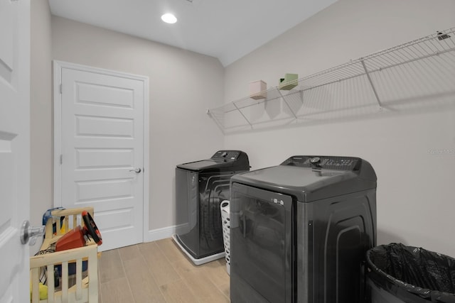 laundry area featuring recessed lighting, washing machine and dryer, laundry area, light wood-type flooring, and baseboards