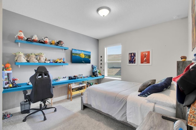 bedroom with a textured ceiling, carpet flooring, and baseboards
