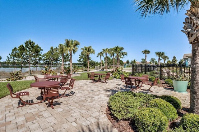 view of patio / terrace featuring a water view and fence
