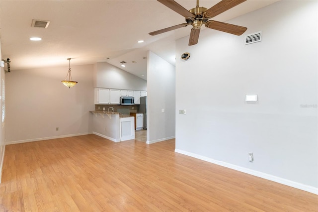 unfurnished living room with light wood-style floors, visible vents, a ceiling fan, and baseboards