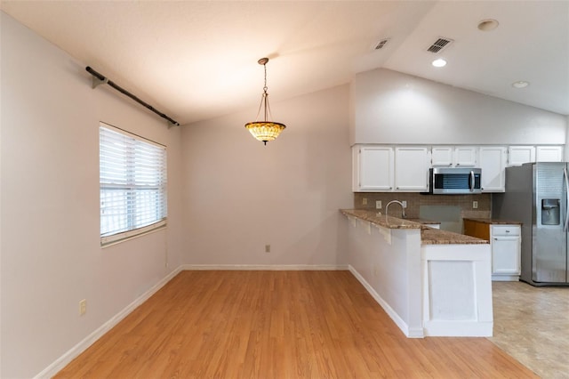 kitchen featuring white cabinetry, appliances with stainless steel finishes, visible vents, light wood-type flooring, and stone counters