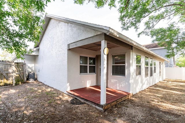 back of property with stucco siding and fence