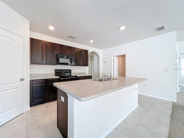 kitchen featuring arched walkways, black appliances, a sink, visible vents, and light tile patterned flooring