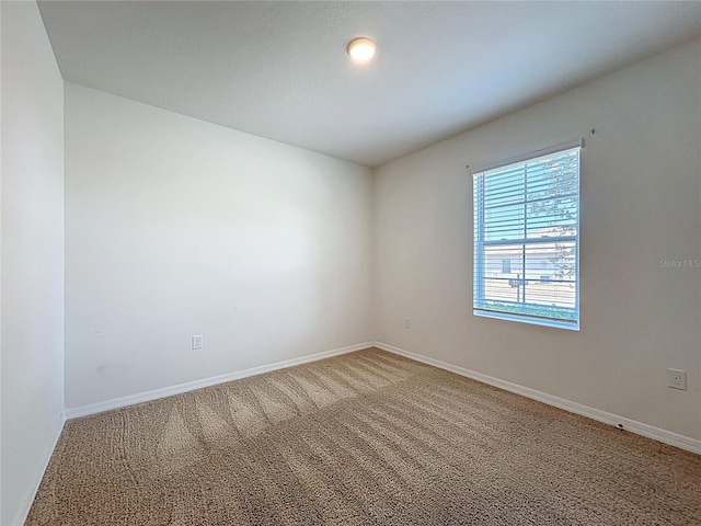 empty room with baseboards and light carpet