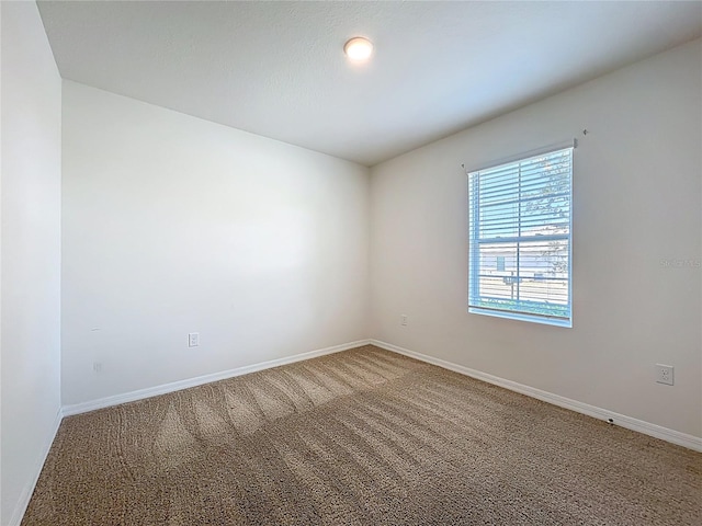 spare room with carpet flooring and baseboards