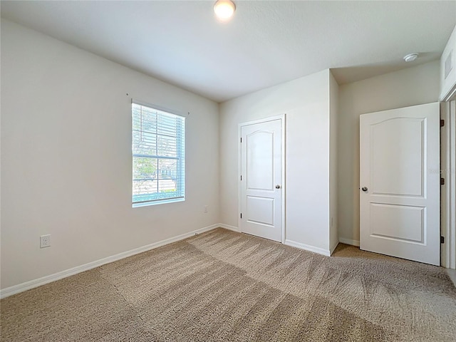 unfurnished bedroom with carpet floors and baseboards