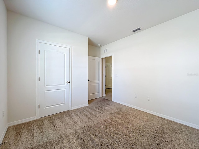 unfurnished bedroom featuring baseboards, visible vents, and carpet flooring