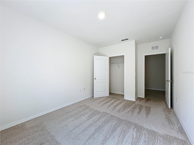 unfurnished bedroom featuring a closet, visible vents, carpet, and baseboards