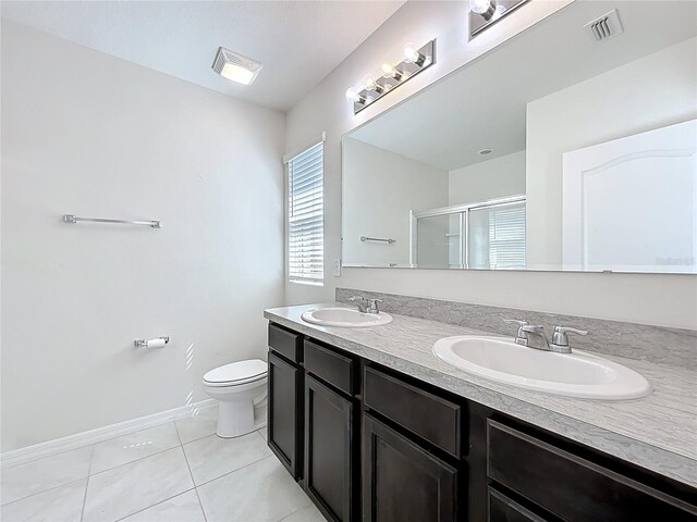 full bathroom with tile patterned floors, toilet, a shower stall, and a sink