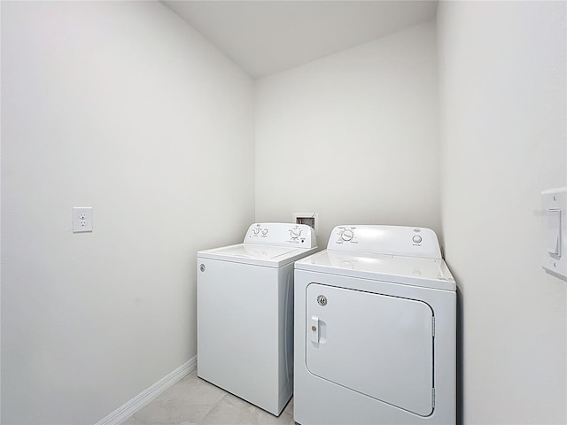 laundry area featuring light tile patterned flooring, baseboards, laundry area, and washer and clothes dryer