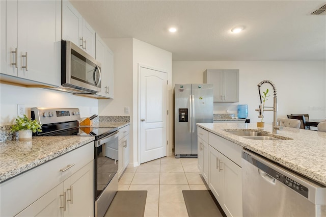 1535 Barberry Dr, Kissimmee, FL 34744 - kitchen featuring visible vents, light tile patterned flooring, light stone countertops, a sink, and stainless steel appliances