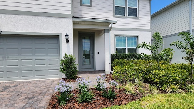 doorway to property featuring driveway and stucco siding