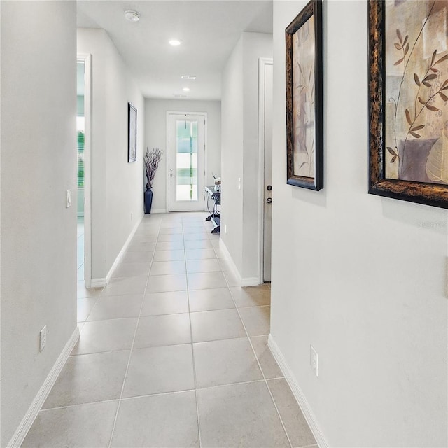 corridor featuring baseboards, recessed lighting, and light tile patterned flooring