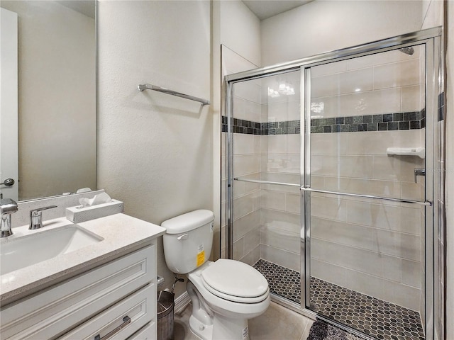 bathroom with toilet, a shower stall, and vanity