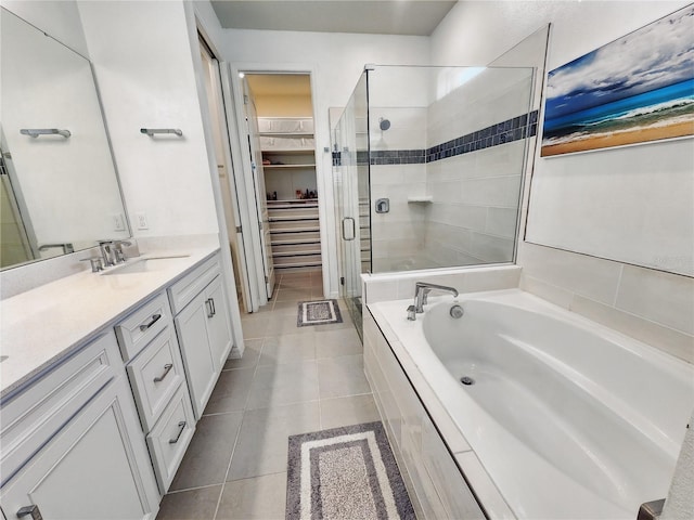 bathroom featuring vanity, a bath, tile patterned floors, a spacious closet, and a shower stall