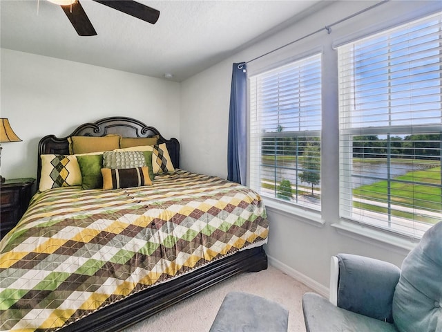carpeted bedroom with baseboards, a ceiling fan, and multiple windows