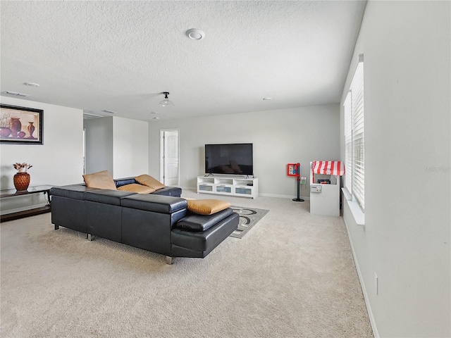 carpeted living room with baseboards, a textured ceiling, and visible vents