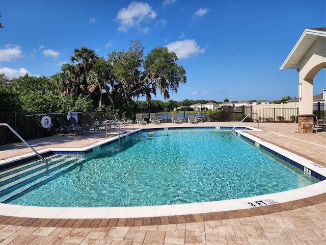 pool with fence and a patio area