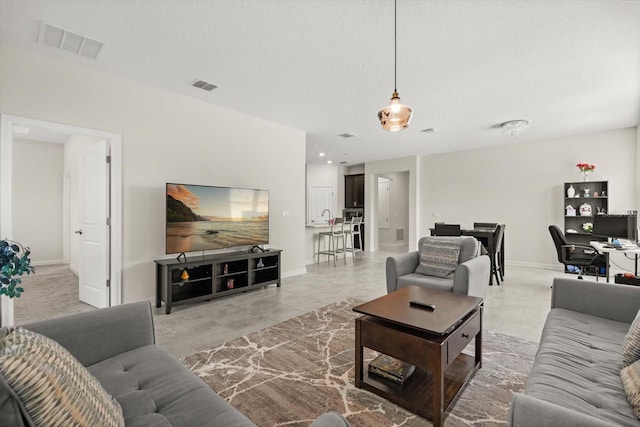 living room featuring light tile patterned floors, visible vents, and baseboards