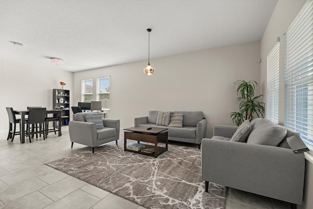 living area featuring tile patterned flooring and a textured ceiling