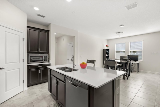 kitchen featuring visible vents, stainless steel appliances, light countertops, and a sink